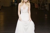 an A-line wedding dress with a lace thick strap bodice and a plunging neckline plus a layered skirt