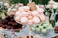 an elegant glass wedding dessert stand with cute birdies on top is a lovely idea for many weddings, from vintage to rustic ones