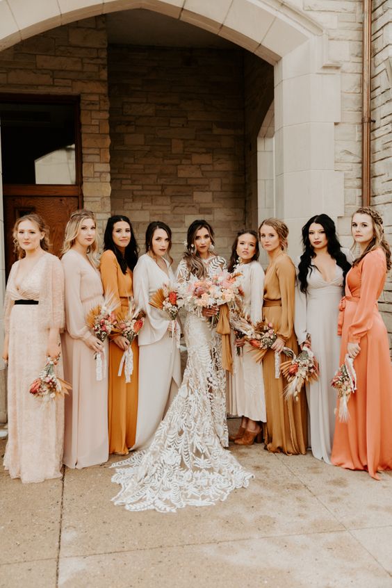 an eye-catchy mismatching bridal party with blush, off-white, orange and yellow maxi bridesmaid dresses with long sleeves