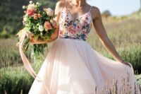 an incredible wedding ballgown with a colorful floral embroidered bodice on spaghetti straps and a blush layered skirt
