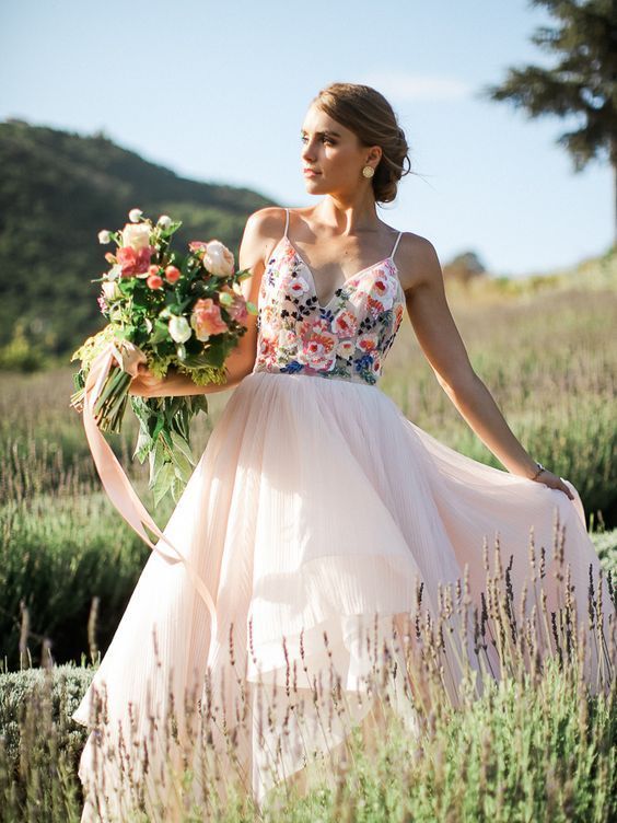 an incredible wedding ballgown with a colorful floral embroidered bodice on spaghetti straps and a blush layered skirt