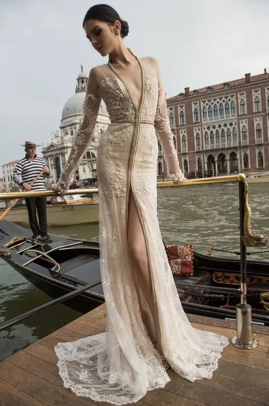 an ivory wedding dress with a plunging neckline, a front slit and illusion lace sleeves