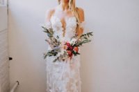 an off the shoulder lace applique wedding dress with a covered plunging neckline and a train