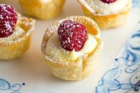 mini lemon tartlets topped with raspberries