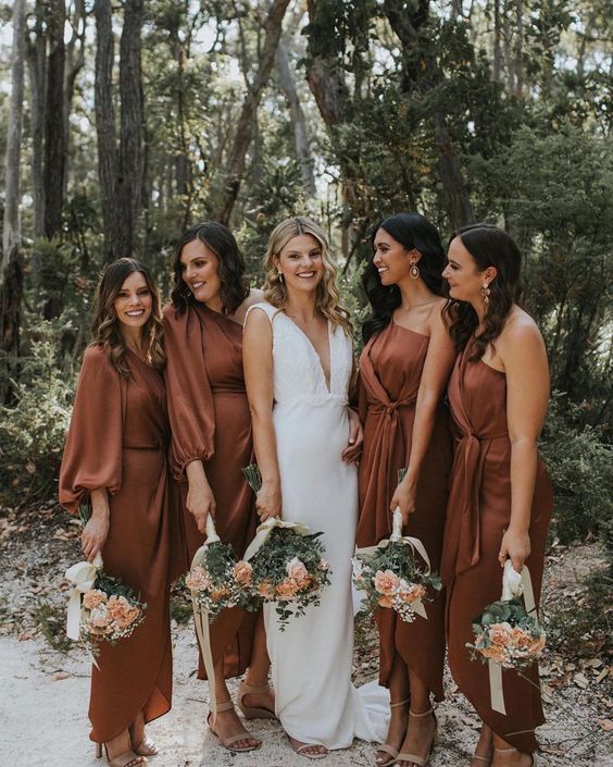 mismatching rust-colored midi bridesmaid dresses with long sleeves and without are perfect for a summer or fall wedding