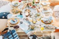 a beach rehearsal dinner picnic with a low table, printed pillows, textiles and porcelain