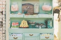 a beautiful vintage candy bar in mint green, with a chlkboard sign, candies in jars and other sweets in jars