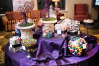 a bright candy bar with a purple tablecloth, monograms, colorful candies arranged in several ways