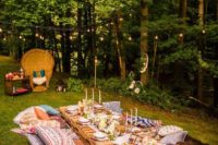 a bright summer picnic with a low table, boho rugs, pillows, candles and an airy runner plus string lights over the table