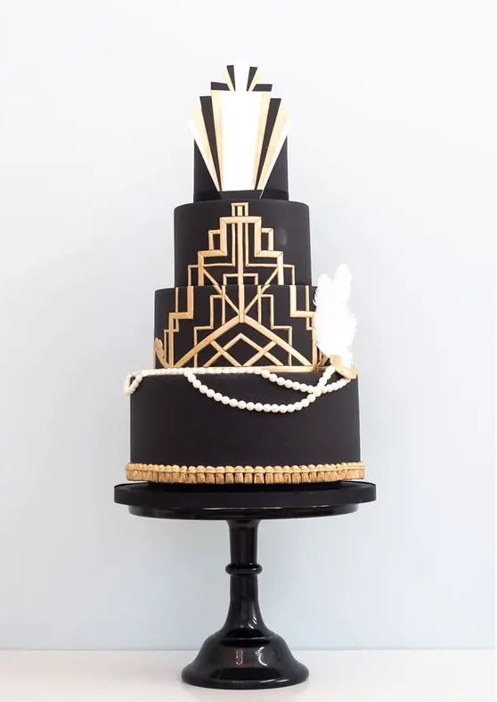 a chic black, gold and white wedding cake with gold geo decor, edible pearls and feathers