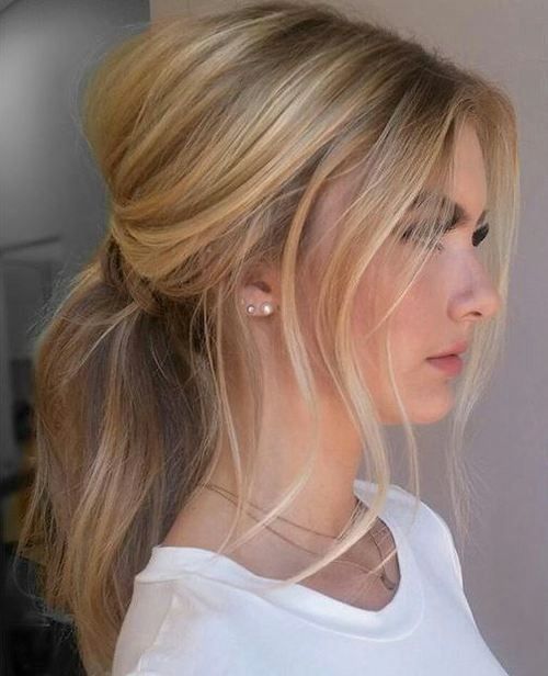 a chic messy and wavy low ponytail with some locks down and a small bump for a chic casual look