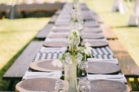 a cozy bbq rehearsal dinner table with plaid linens, wood slice placemats, neutral blooms and greenery