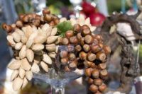 a creative wedding centerpiece of a glass bowl filled with various nuts and driftwood is amazing for a wedding