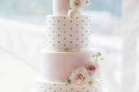 a delicate wedding cake with pink marble and black and white polka dot tiers, white and blush blooms is a chic and refined dessert for a blush wedding