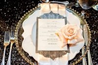 a glitz and glam 1920s tablescape with a black sequin tablecloth, a gold rim charger, neutral napkins and blush roses