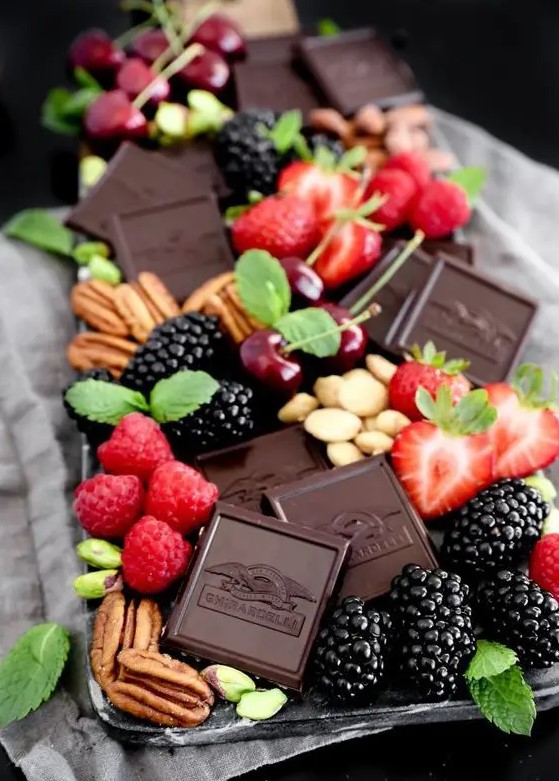 a gourmet sweets board with dark chocolate, fresh berries, nuts, herbs will just blow your mind with its tastes