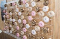 a large acrylic stand with hooks and lots of glazed donuts is a very modern and fresh idea