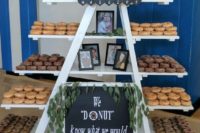 a large donut table done with a ladder and shelves attached to it, with lots of donuts, photos and a sign