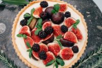 a large tart with custard, figs, blackberries and fresh mint is a delicious decadent dessert for a fall wedding