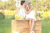 a lemonade kissing booth with white blooms and lemons in jars is ideal for a summer wedding
