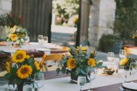 a lovely wedding tablescape with bright sunflower centerpieces and white linens is elegant and simple at the same time