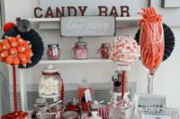 a modern neutral candy bar with a sign and letters, with bright candies in hars and bowls plus thongs to get them easily