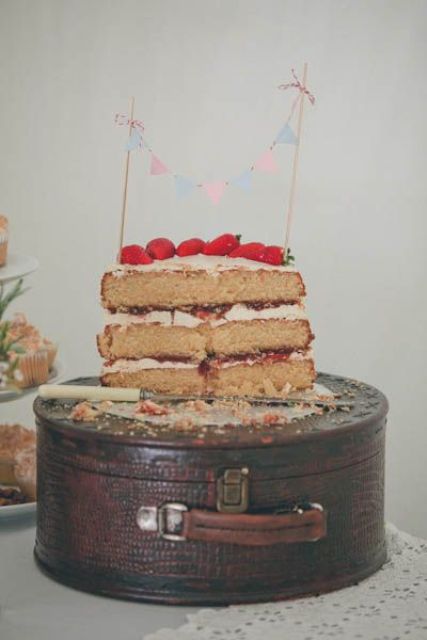 a pretty round suitcase used as a wedding cake table or plate is a very creative and fun idea for a wedding