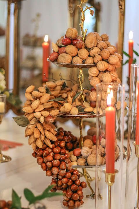 a tiered wedding centerpiece with lots of various nuts and candles around is a lovely idea for a wedding with a touch of whimsy