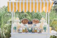 a vintage popcorn bar cart with colorful popcorn, nuts and candies in glass jars of various sizes and shapes