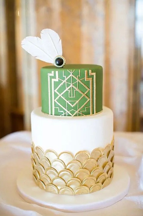 a wedding cake with gold scallops, a green layer with gold geo decor and edible feathers is perfect for a 1920s wedding or party