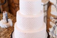 a white polka dot wedding cake with bird cake toppers is a lovely idea for a spring or summer wedding