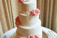 a white wedding cake with gold polka dots, pink and neutral blooms of sugar is a lovely idea for a spring or summer wedding