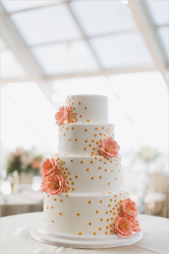 a white wedding cake with gold polka dots, pink sugar blooms is a lovely idea for a bright wedding in summer or spring