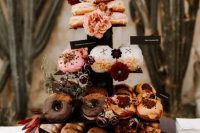 amazing donuts with glazing, nuts, blooms and greenery are great as an alternative to a usual wedding cake