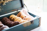 an elegant blue vintage box with tasty glazed donuts and baby’s breath for stylish serving