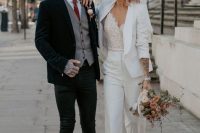 an elegant groom’s look with black skinnies, a white shirt, a red tie, a grey waistcoat and a navy velvet blazer, head and hand tattoos