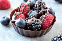 chocolate cups with fresh raspberries, blackberries, blueberries and chocolate sauce