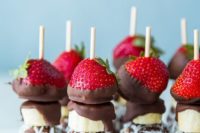 creative skewers of chocolate balls with coconut, bananas, chooclate and strawberries for a summer wedding