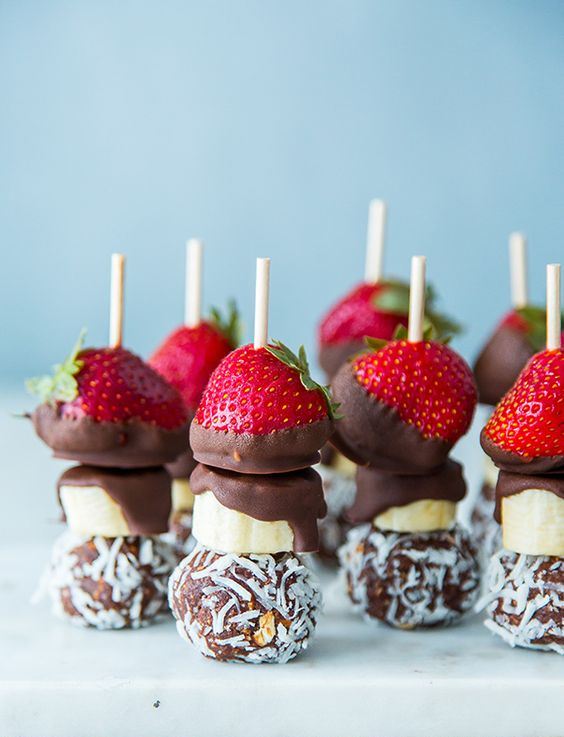 creative skewers of chocolate balls with coconut, bananas, chooclate and strawberries for a summer wedding