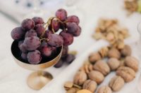 serving food Mediterranean style – grapes in a gold bowl, apricots and nuts on a tray are amazing for a wedding