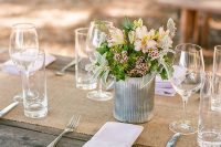 simple rustic tablescape styling with uncovered tables, a burlap runner, blush blooms and greenery in a tin can and silver