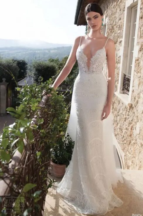 a super sexy and bold sheath spaghetti strap wedding dress with a plunging neckline and a train just wows, and statement earrings add to the look