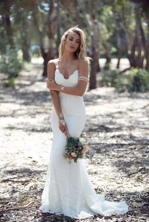 a sexy lace mermaid wedding dress with a deep V-neckline and a small train is classics for a bride who wants to look flirty, chic and very feminine