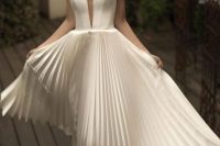 20 an exquisite A-line wedding dress with a corset bodice with a plunging neckline and a pleated midi skirt is an out of the box idea