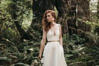 a gorgeous plain A-line wedding dress with a depe neckline, a shiny metallic belt and a pleated skirt with a long train plus floral earrings