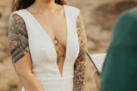 33 a modern plain sheath wedding dress with a plunging neckline, no sleeves showing off the tattoos for even a sexier look