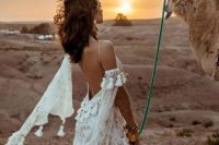 46 a boho A-line wedding dress in white, with gold lace detailing, tassels, a low back and a cold shoulder is very refined and chic