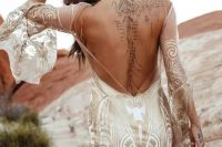 48 a boho mermaid wedding dress in white with gold lace detailing, a low back, bell sleeves and a train is chic