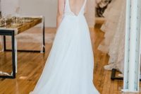 50 a chic A-line wedding dress with spaghetti straps, an open back and a long sweeping train looks beautiful
