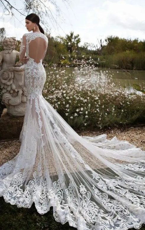 a lace mermaid wedding dress with an open back, long sleeves and a long train makes a statement with its style and catches an eye with its back
